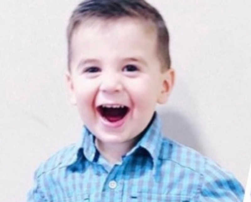 Adopted little boy smiles with mouth open as he wears collared shirt