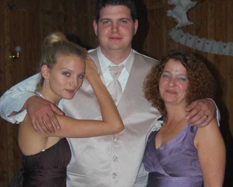 Drug addict stands with arm around wife and mother