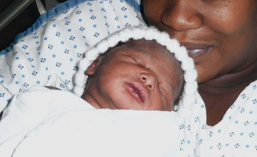 Newborn lays on back on birth mother's chest