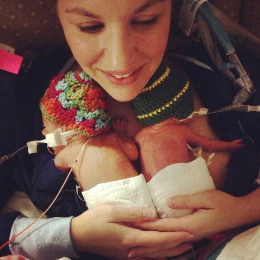 Mother smiles as intubated preemies lay on her chest