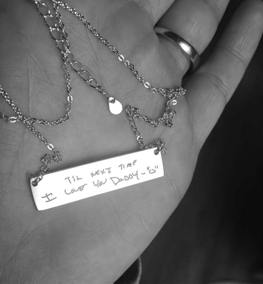 Necklace in woman's hand with engraving on it of something her deceased father once said