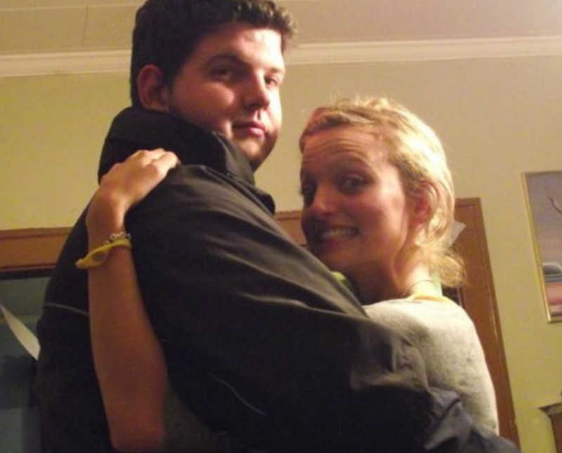 Drug addict smiles in home as he stands hugging his wife