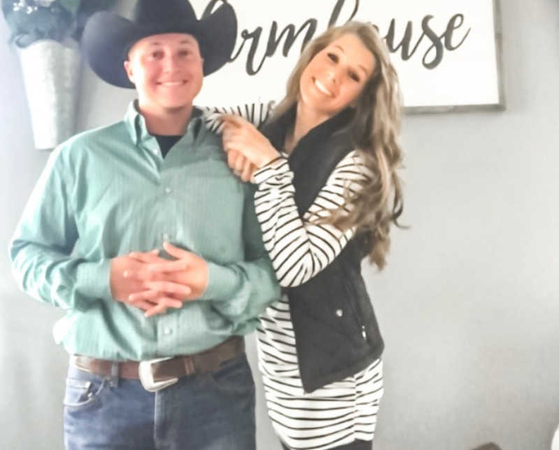 Husband and wife who are licensed foster parents stand smiling in their home