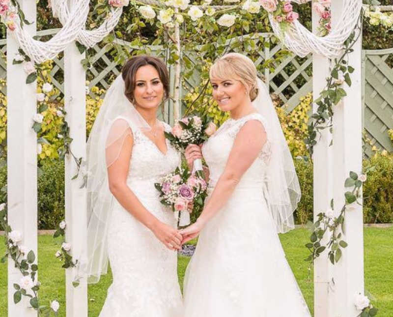 Bride's stand at altar smiling and holding hands