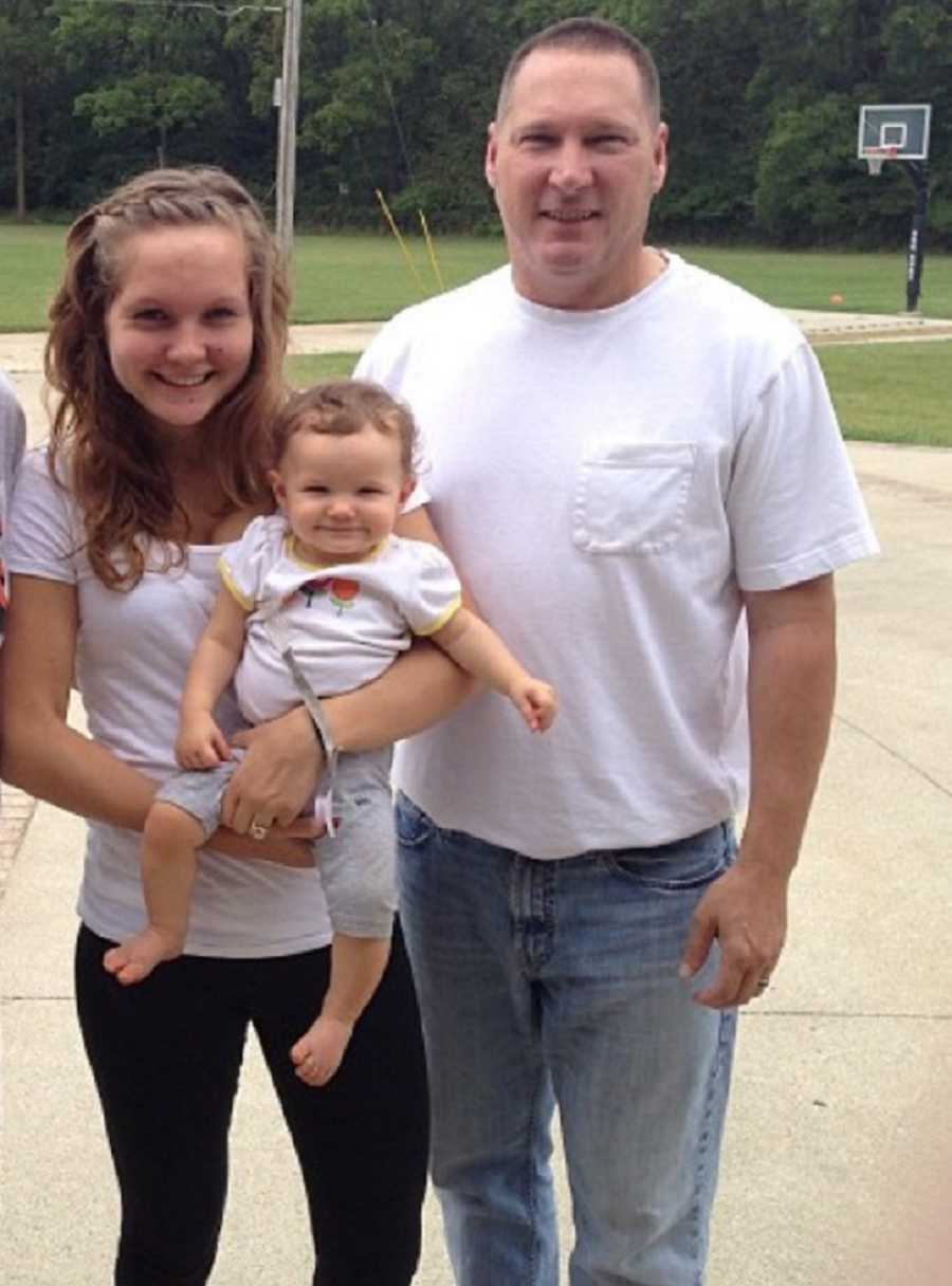 Man who has since passed stands in driveway beside daughter who holds her baby