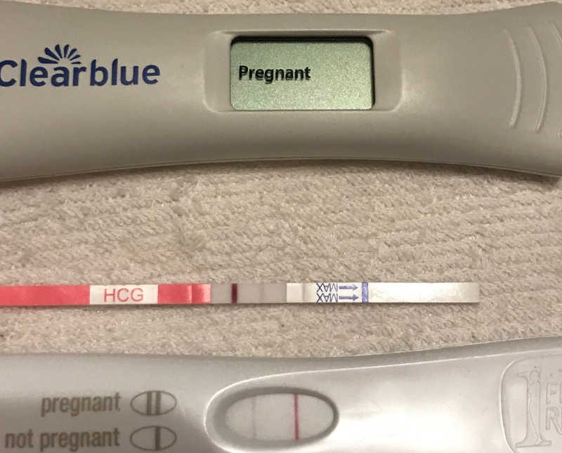 Two pregnancy tests laying side by side, one says pregnant and one says not pregnant 