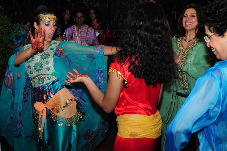 Woman who survived shooting stands in traditional Indian clothing dancing with others