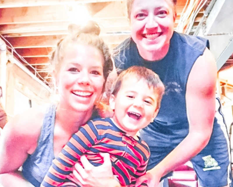 Husband and wife smile in selfie with their adopted little boy 