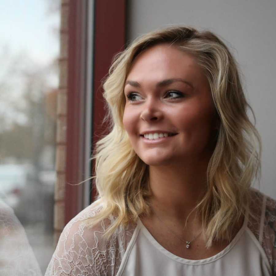 Woman whose husband divorced her smiles as she sits looking out window