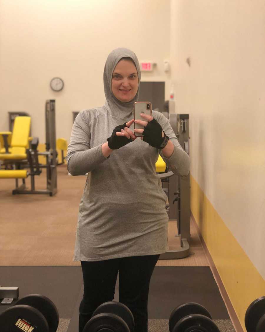 Woman who converted to Islam smiles in mirror selfie at gym