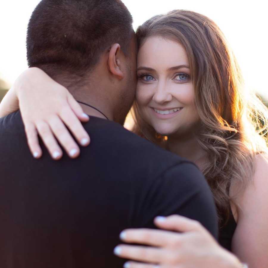 Wife smiles as she hugs her husband 