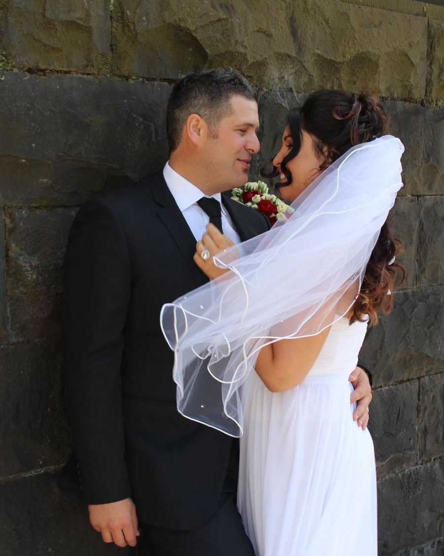 Woman who advocates for healthy relationships stands in arms of groom on their wedding day