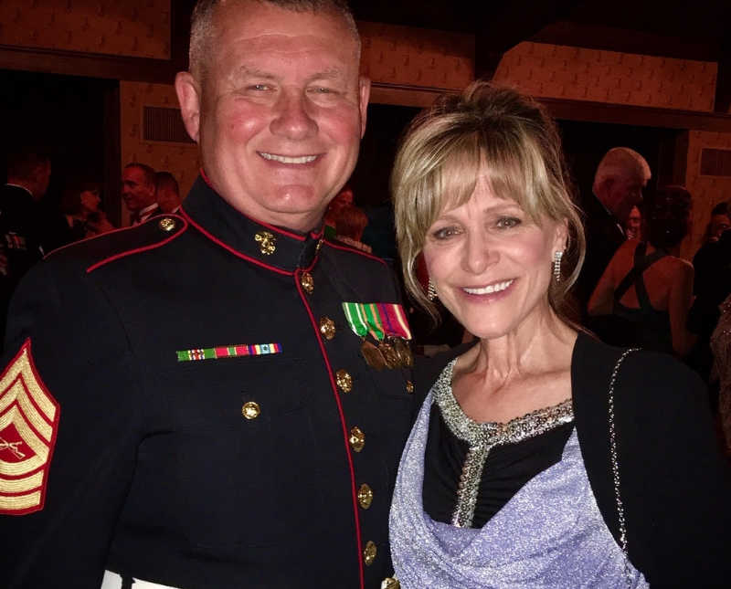 Woman with papillary thyroid carcinoma stands smiling beside husband in military