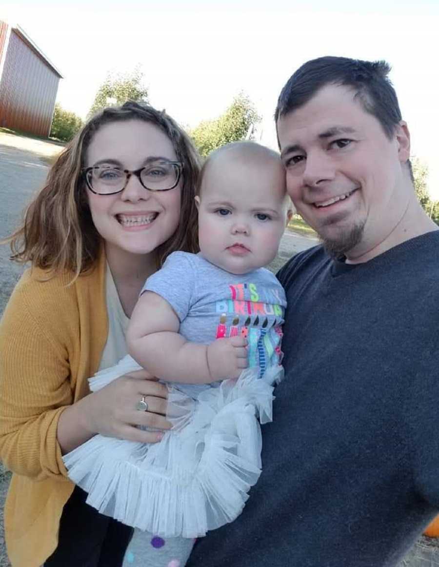 Husband and wife smile as they hold their baby girl before she passed away