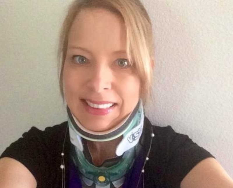 Woman with neck brace on smiles in selfie