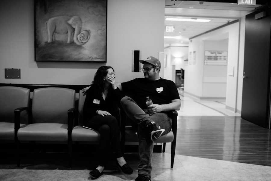 Husband and wife sit in hospital waiting room waiting for their adopted child to be born