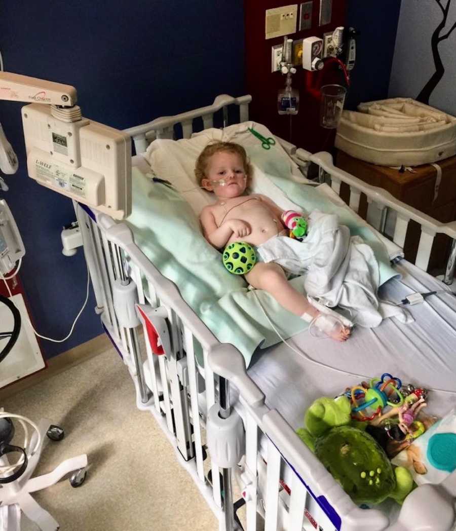 Intubated epileptic little girl lays in crib of hospital 