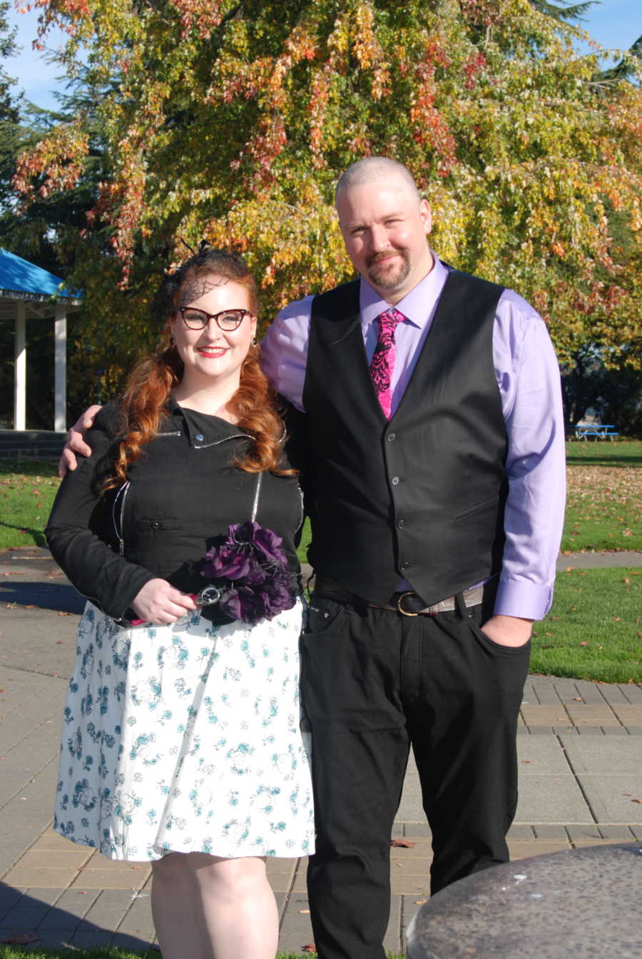 Boyfriend and girlfriend who spent most of their relationship apart from each other stand smiling outside