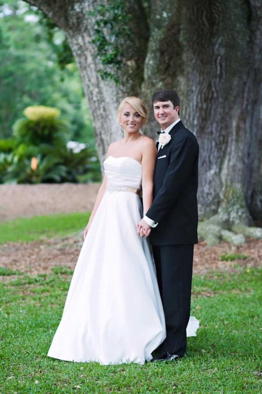 Bride with eating disorder stands outside holding groom's hand
