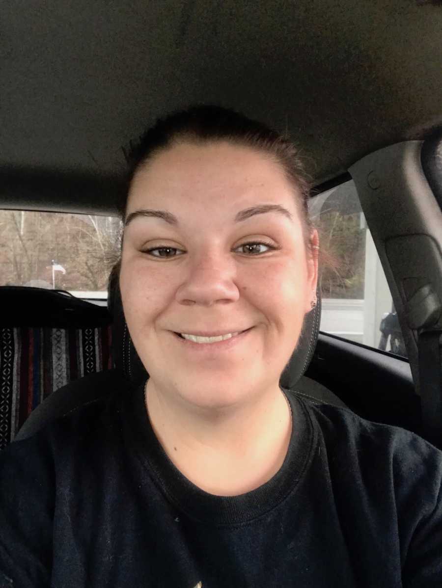 Woman who dated a man she didn't know was married sits smiling in car 