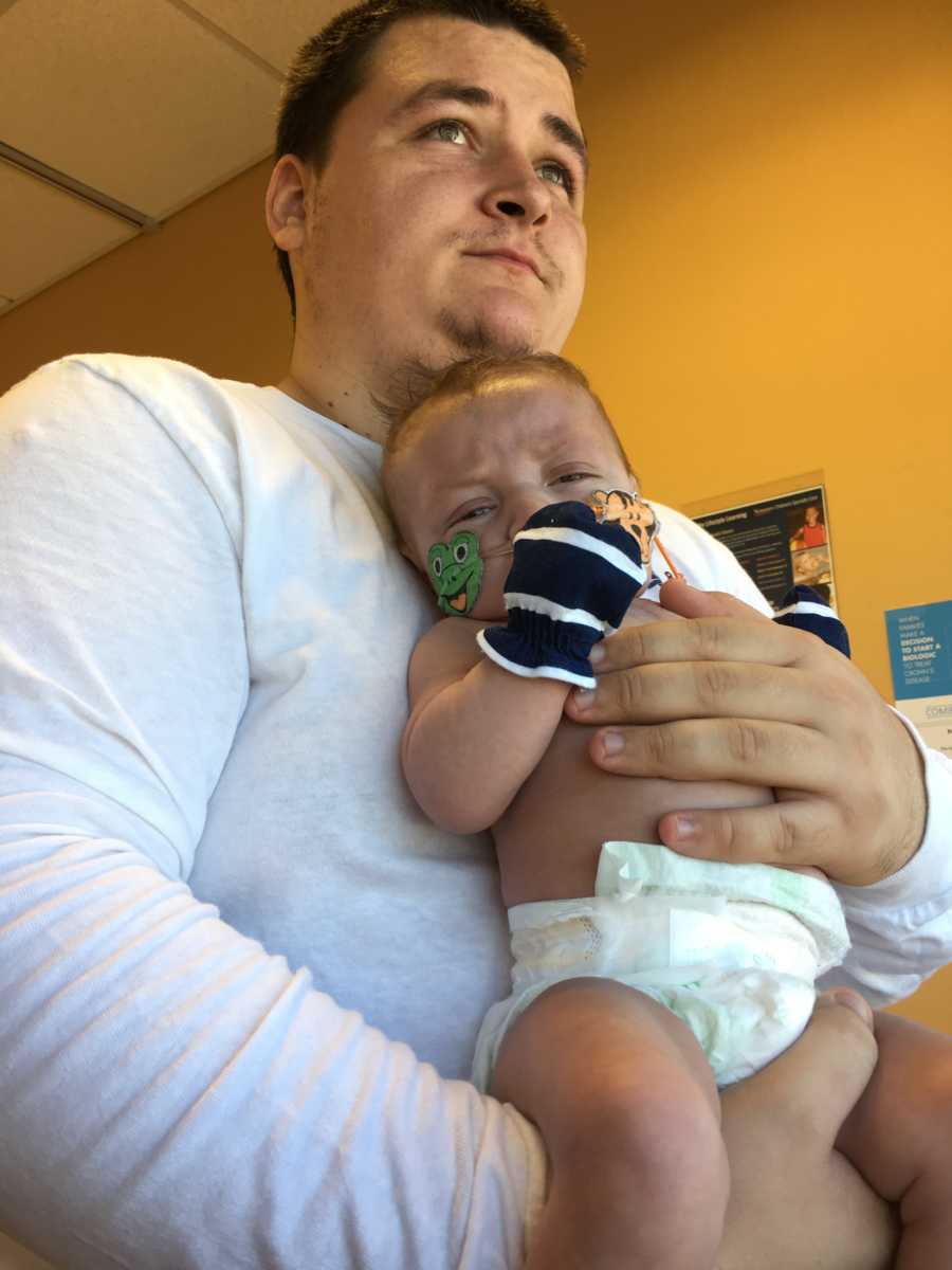 Father stands in hospital holding baby with Hypoplastic Left Heart Syndrome