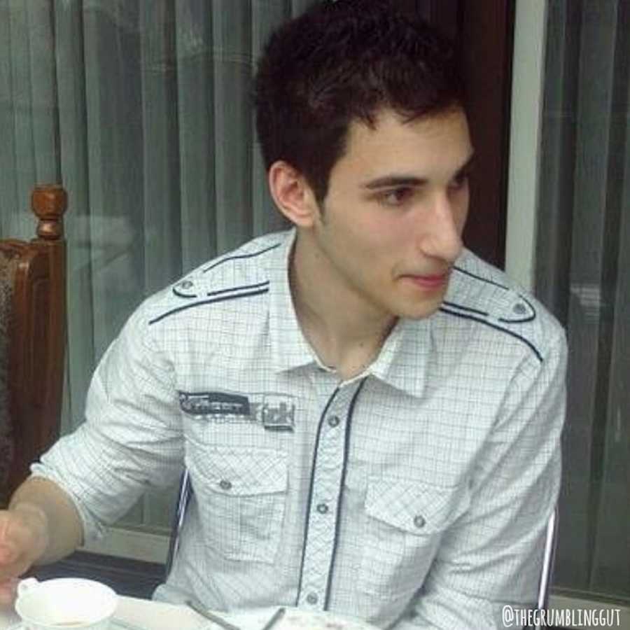 Man with invisible disease sits at table with tea cup in front of him