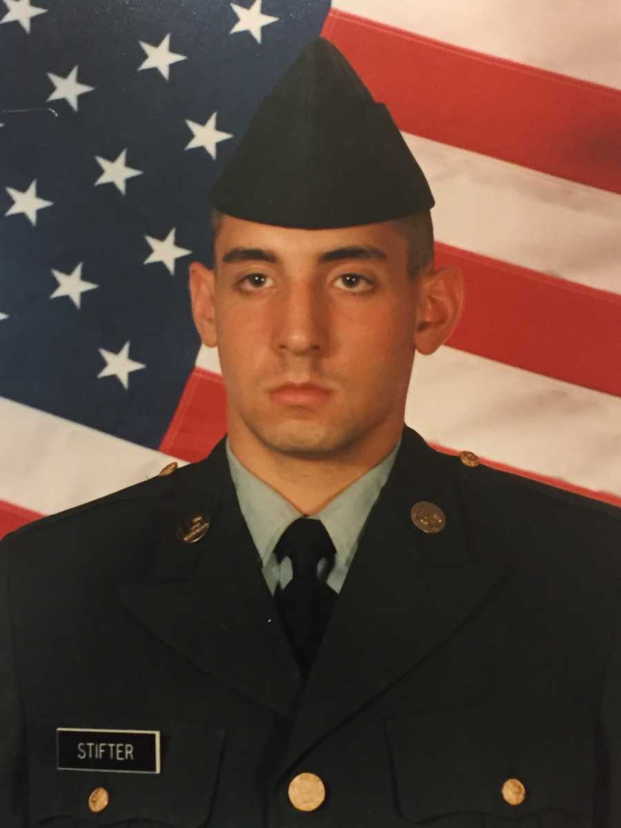 Young man sitting in uniform in front of American flag who would later in life drown in lake and die