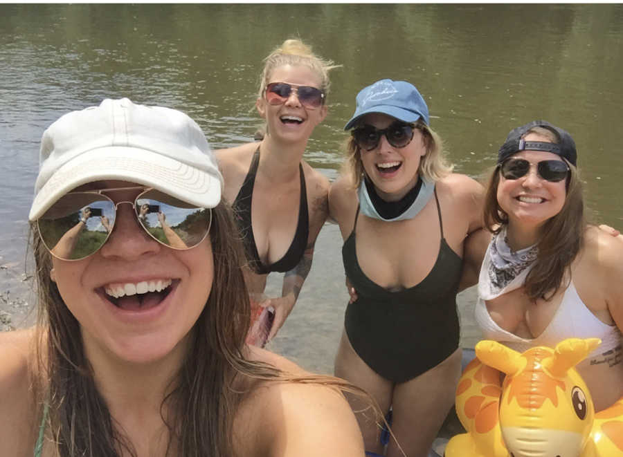 Woman smiles in selfie in body of water with three friends who also have Cystic Fibrosis