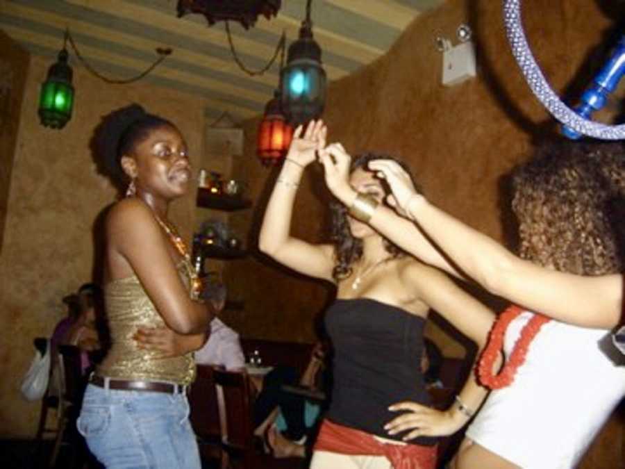 Three young woman dancing in club before shooting