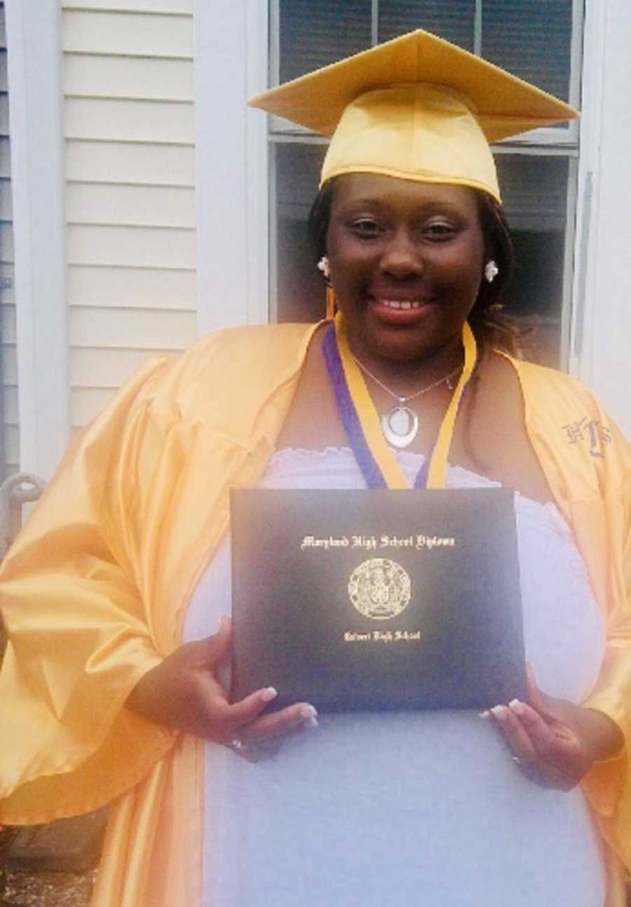 Young woman who was raped by her uncle when she was little stands outside home in cap and gown holding diploma