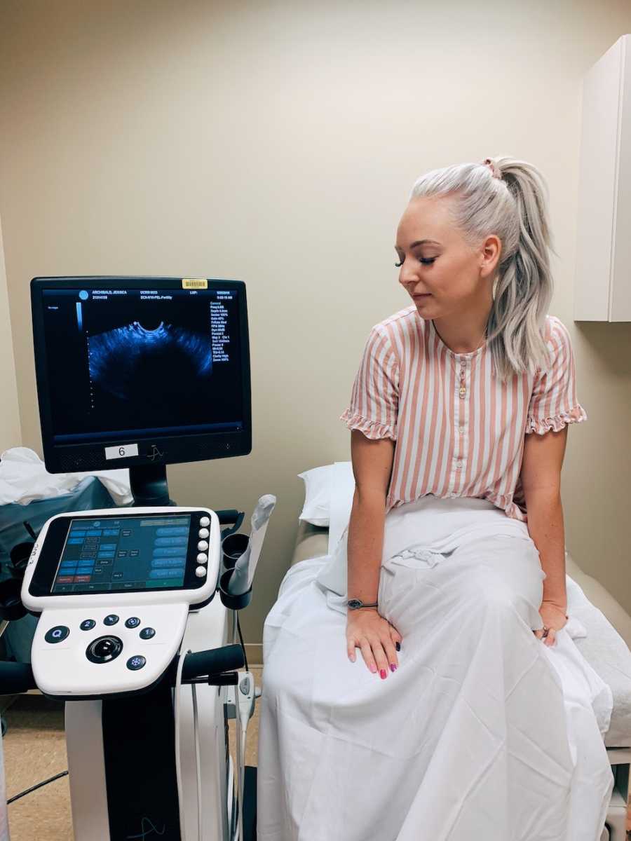 Woman sits at ultrasound appointment next to machine