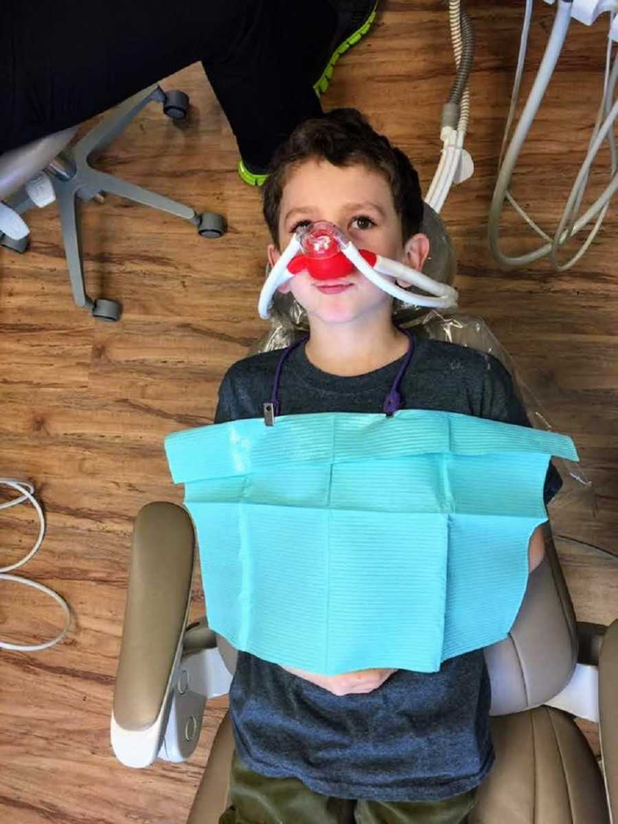 Young boy who has cleft lip and palate surgery lays in dentist chair