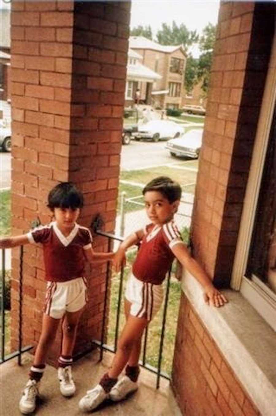 Little boys stand on front porch of home in Chicago in soccer uniforms