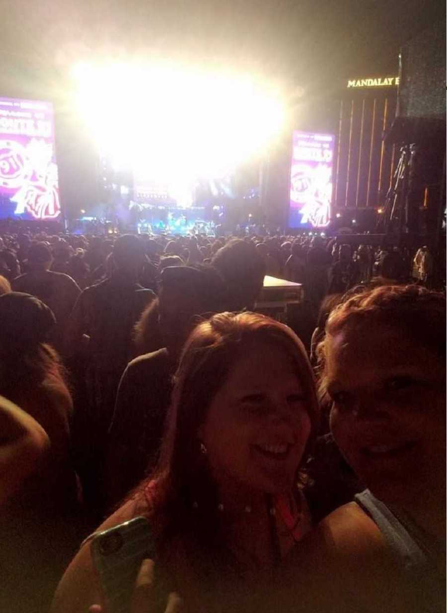 Friends take selfie with concert in background in Vegas before shooting