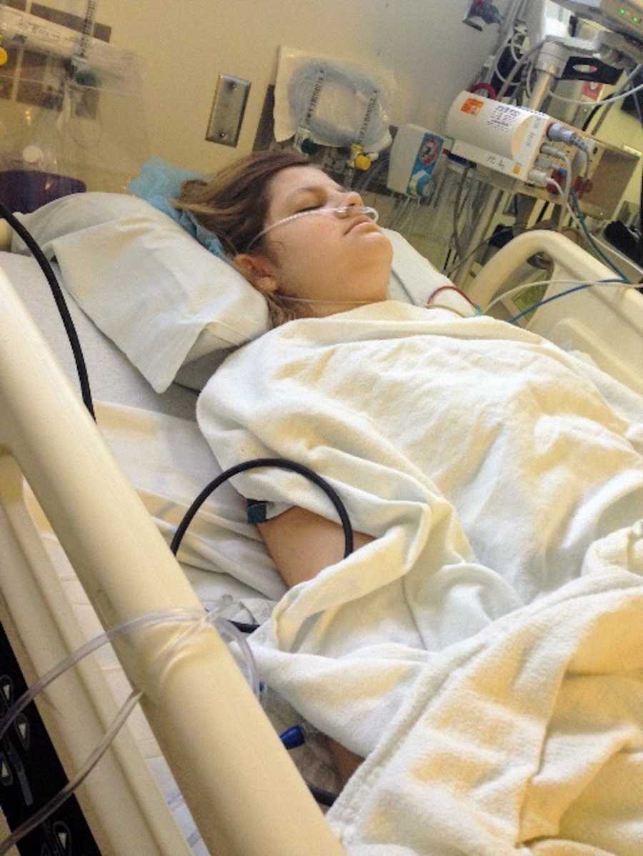 Woman on oxygen lays asleep in hospital bed after surgery