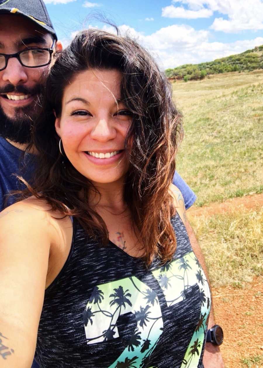 Woman whose brother sexually abused her stands smiling outside with her husband
