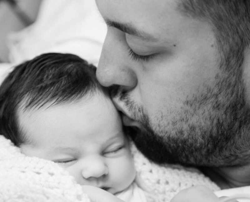 Father kisses newborn on head who will soon pass away