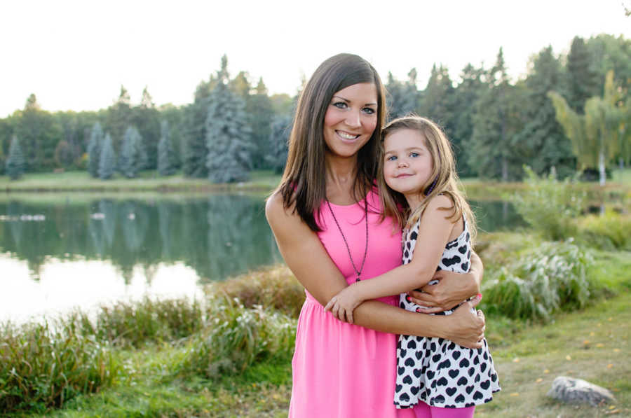 Woman with Guillain-Barre syndrome stands smiling outside as she has her arms around daughter