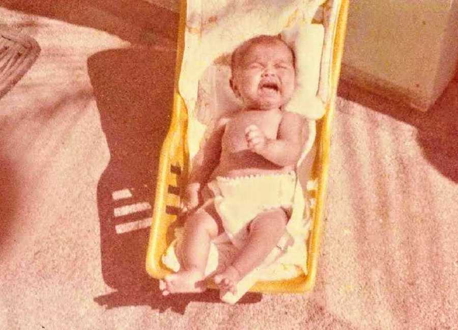 Baby lays crying in crib