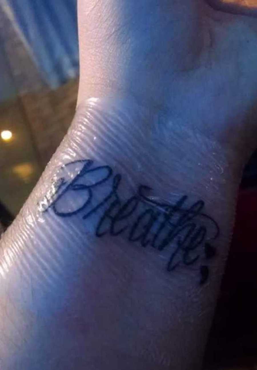 Close up of tattoo on woman with OCD's wrist that says, "breathe"