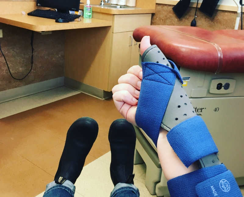 View from young woman sitting in doctor's office room with brace on her arm 