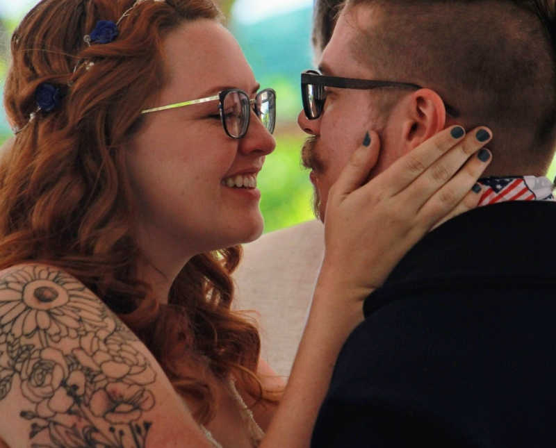 Bride with Thoracic Outlet Syndrome smiles as she holds groom's face