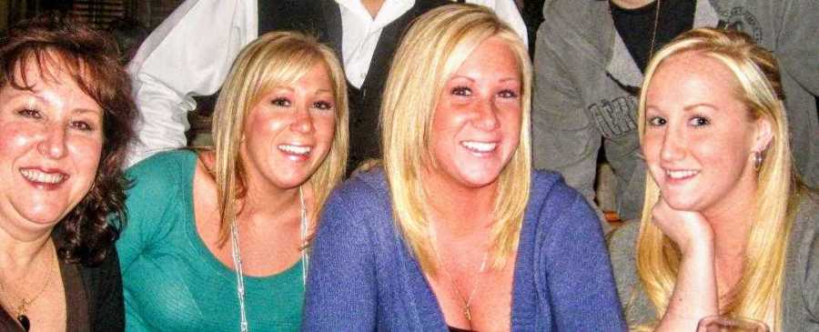 Woman who has since passed away sits smiling with mother and two sisters