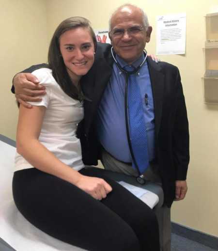 Woman sits in doctors office with arm around doctor who diagnosed her with MALS