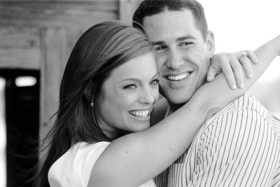 Woman who sometimes doesn't want to be touched stands smiling as she hugs her husband