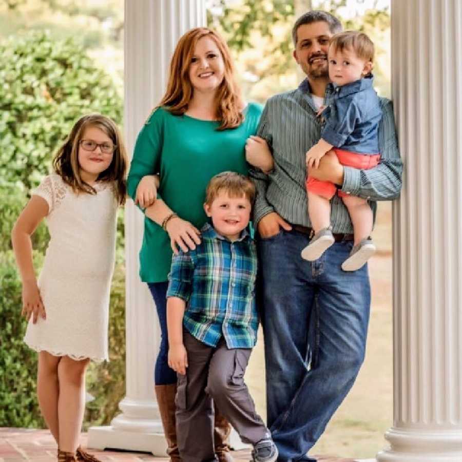 Woman smiles outside beside her husband who was shot and killed and her three kids