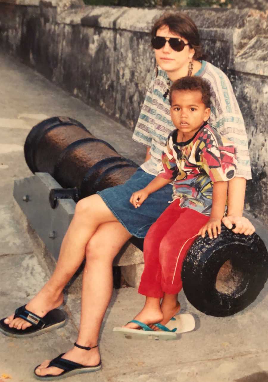 Mother sits on canon beside her young boy 