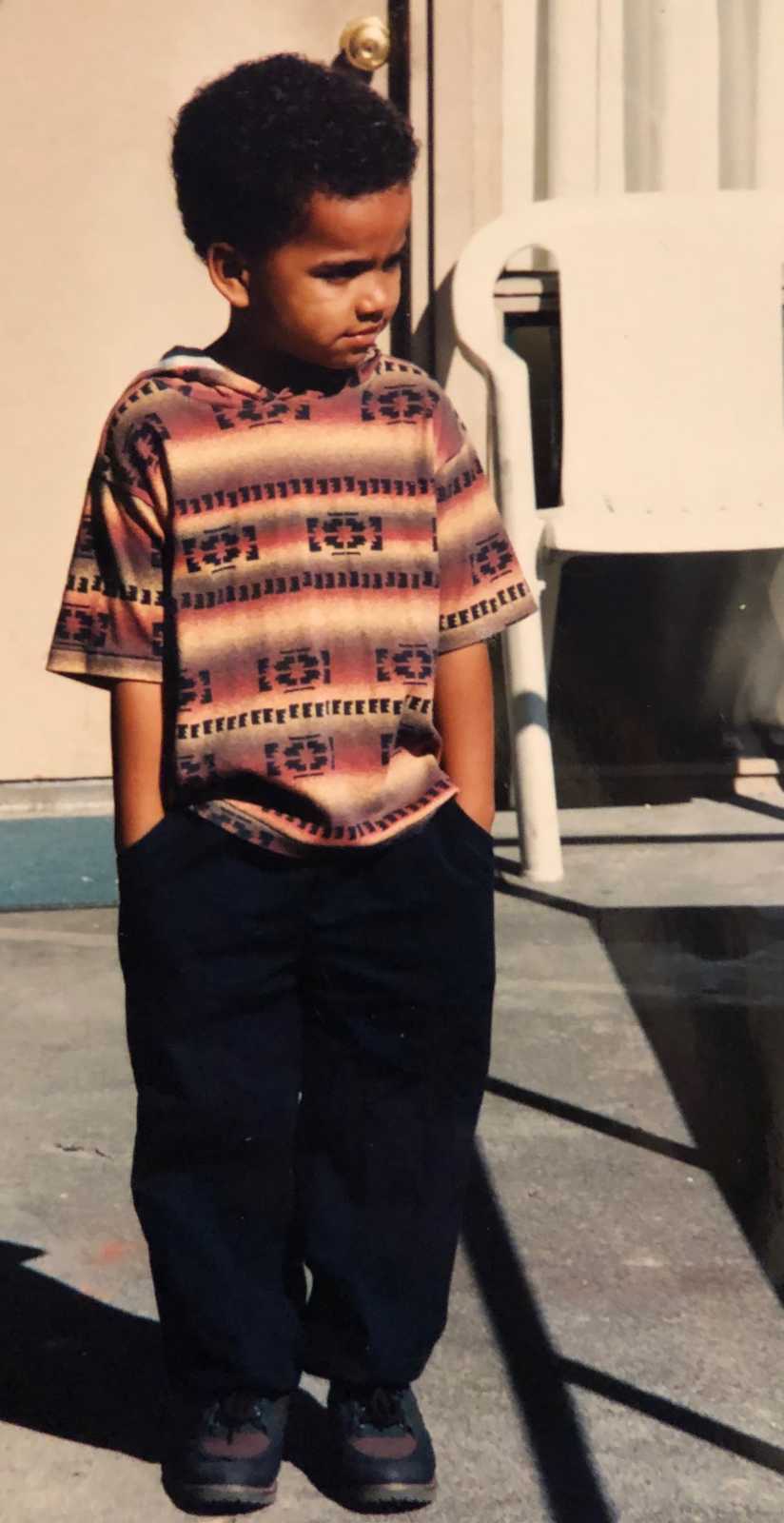 Little boy stands outside with hands in his pocket