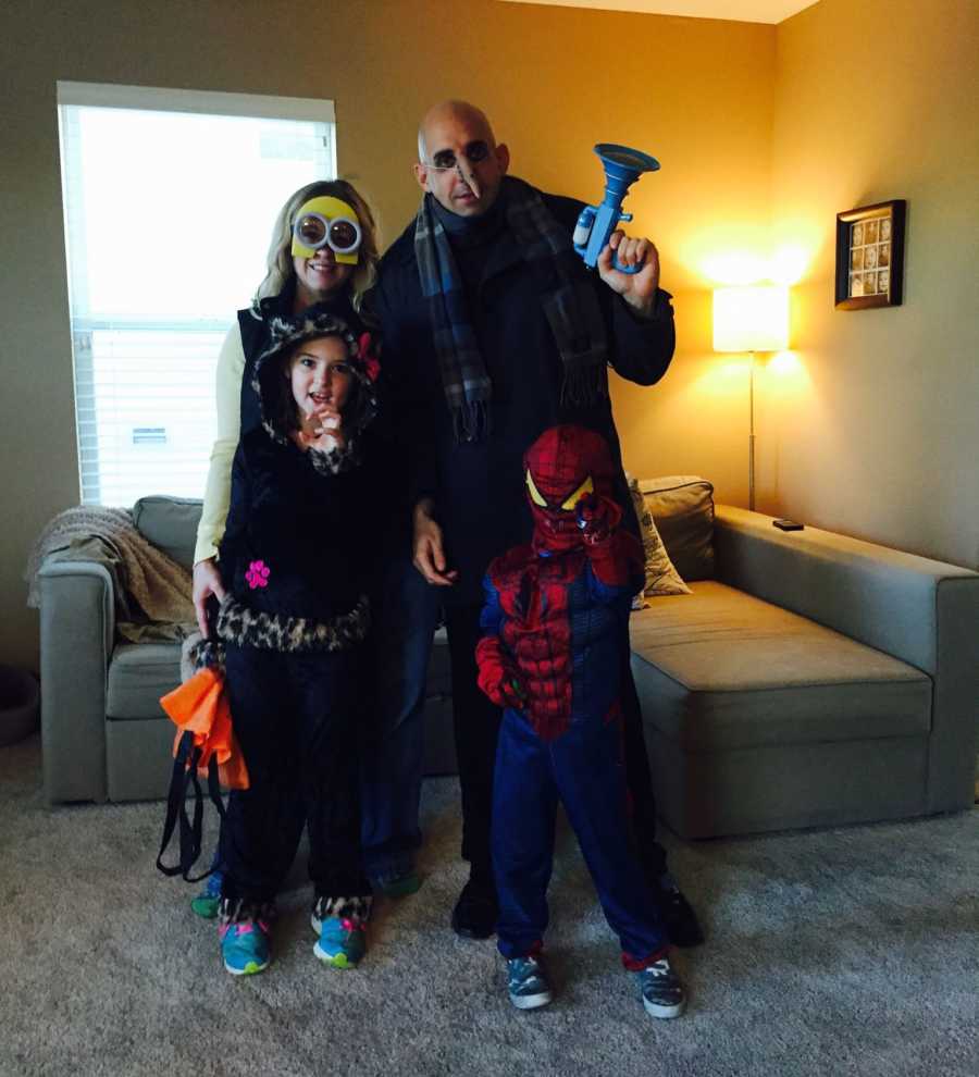 Husband who has since passed stands in home with wife and kids who are all dressed for Halloween