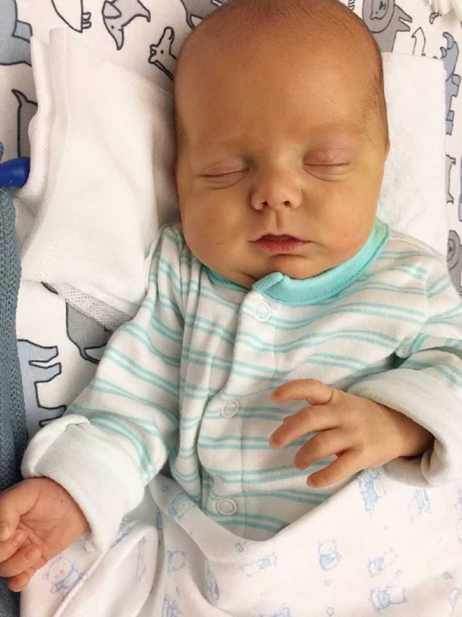 Baby who was in NICU for a while after birth lays on back asleep